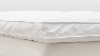 A white mattress box with a white topper on top.
