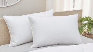 Two white down pillows on a bed.