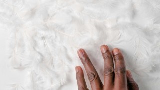 A hand touching a white surface.