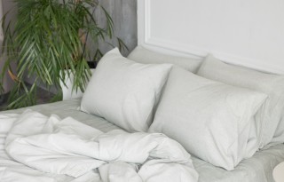 A white bed with pillows and a comforter.